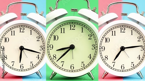 4K footage Time-lapse Three classic white twin-bell alarm clocks are displayed side by side, each showing different time set against vibrant split-tone pastel backgrounds.