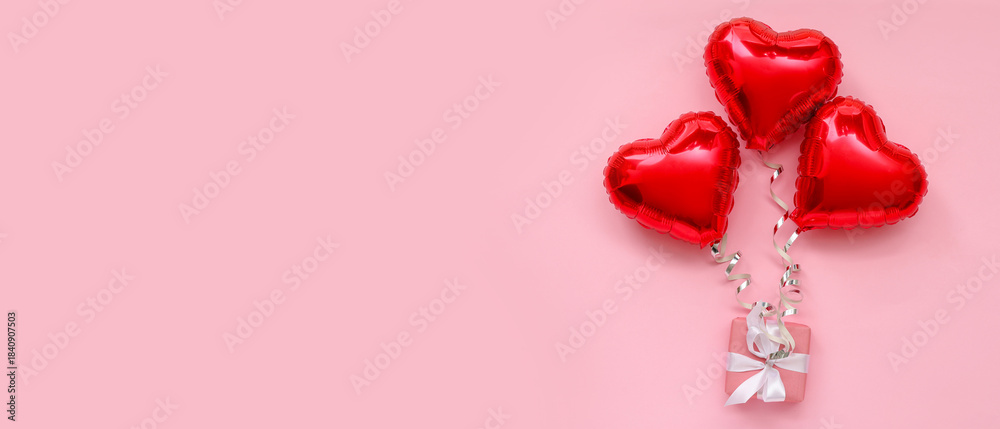 Fototapeta premium Composition with gift box and heart shaped balloons on pink background. Valentine's Day celebration