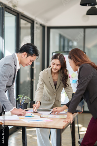 Group of Asian businesspeople sits down for a business investment planning meeting.