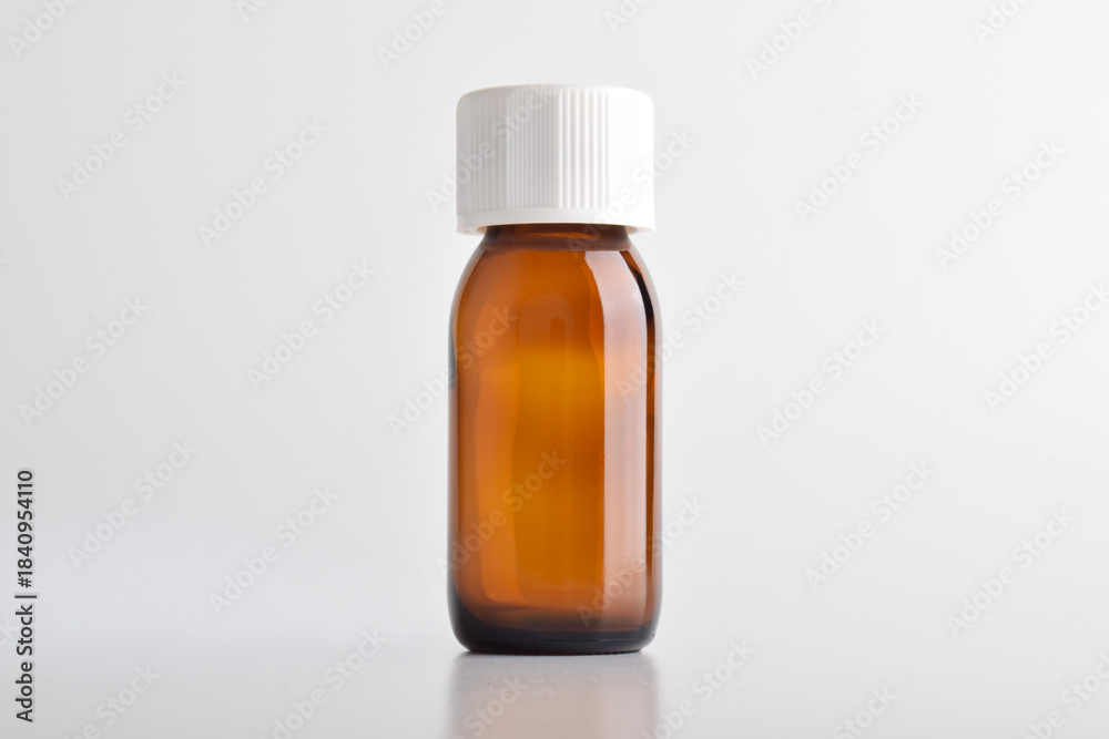 Fototapeta premium Brown glass bottle with white cap isolated on white background.