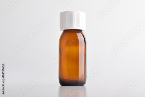 Brown glass bottle with white cap isolated on white background.