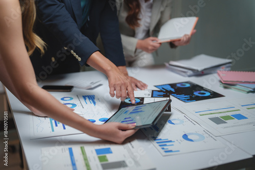 Business professionals analyzing financial data using tablet and charts