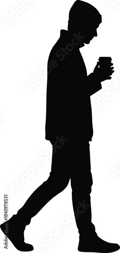 Silhouette of a young man walking while holding a coffee cup