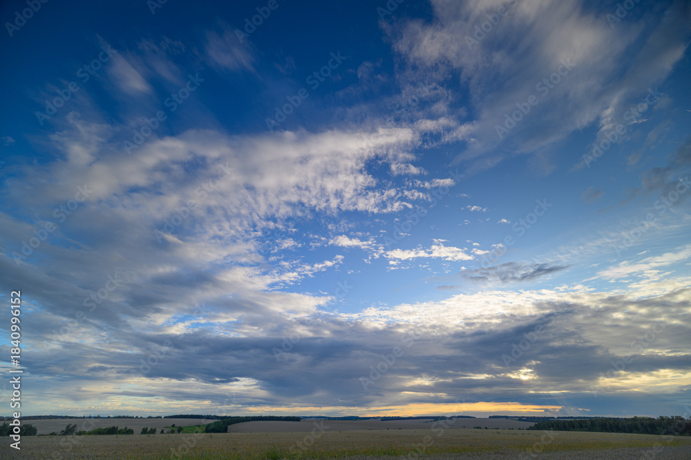 Fototapeta premium A Beautiful Sunset Sky Showcasing Dramatic Clouds Hovering Over a Serene Landscape