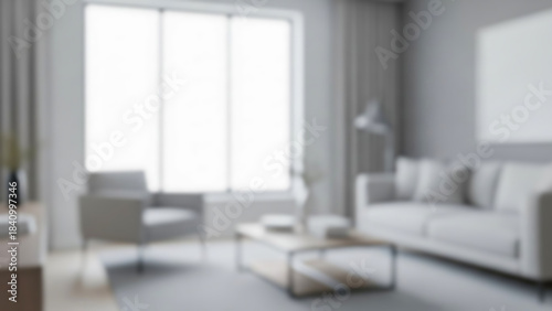 Blurred bright modern living room interior featuring contemporary grey sofa, armchair, and coffee table against a large sunlit window, creating a serene and spacious home environment