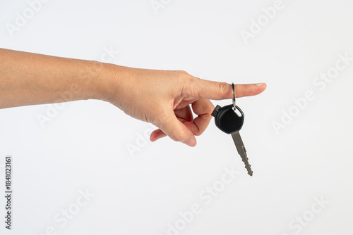 A black motorcycle key in a hand against a white background.