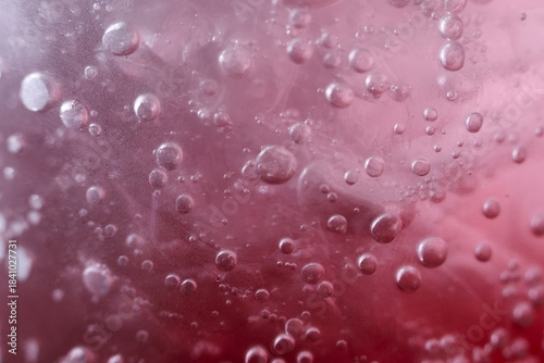Refreshing macro close up of fizzy red liquid with effervescent bubbles. This vibrant abstract background of carbonated drink creates dynamic and energetic feeling