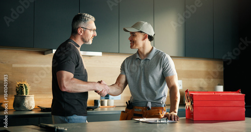Slika na platnu Men, plumber and client with handshake in kitchen for solution, maintenance and leak repair