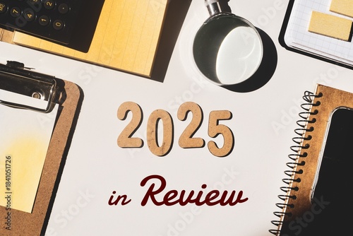 2025 year in review concept with wooden numbers and inscription on desk. Set of office supplies. 2025 evaluation, recapitulation, look back.