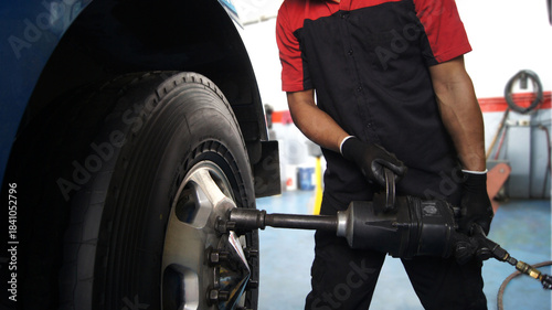 Konstfotografi Mechanic changing tires on a truck using a pneumatic impact wrench in an auto repair shop
