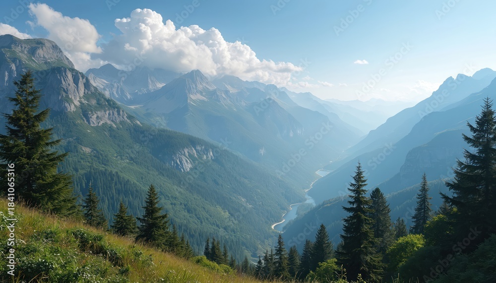 Fototapeta premium Vast mountain range with green forested slopes and a winding river. Clear blue sky with fluffy clouds above. Pine trees frame foreground meadow.