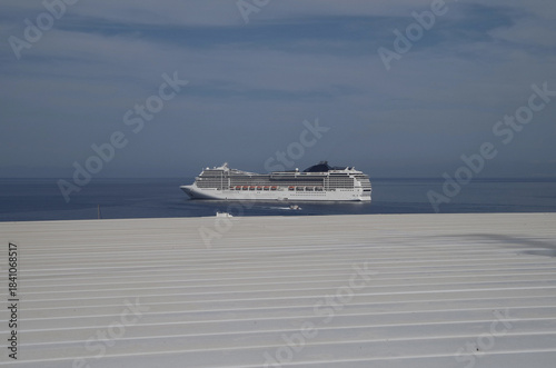 Luxury modern Italian cruiseship cruise ship liner Magnifica at sea anchoring in front of Mykonos Island in summer during Mediterranean Aegean Greek Island cruising dream vacation