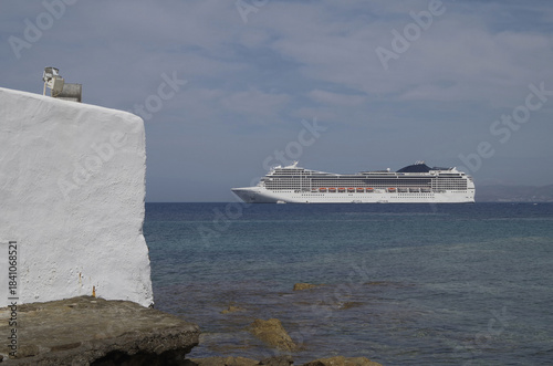 Luxury modern Italian cruiseship cruise ship liner Magnifica at sea anchoring in front of Mykonos Island in summer during Mediterranean Aegean Greek Island cruising dream vacation