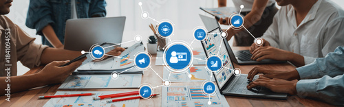 Panorama shot analyst team utilizing BI Fintech to analyze financial report with laptop. Businesspeople analyzing BI power dashboard displayed on laptop screen for business insight. Scrutinize Amity