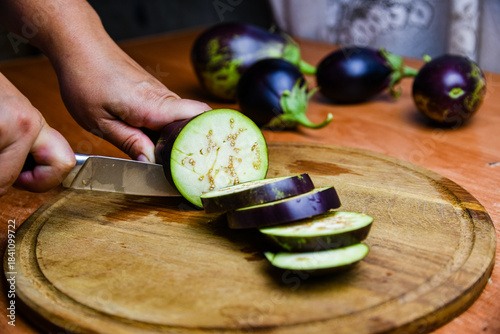 Woman cutting eggplant on the cutting board