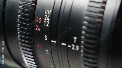 Close up shot of professional camera lens with focus distance ring. The focus distance wheel rotating slowly adjusting the focus