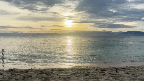 Tranquil Beach Bliss: Golden Sunrise/Sunset Over Calm Waters and Majestic Mountains. HDR Video, Seamless Loop