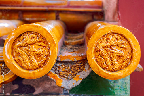 Close view of golden roof tiles with carved dragon motifs shows refined craftsmanship and strong symbolic decoration within historic palace setting in Forbidden City, Beijing, China