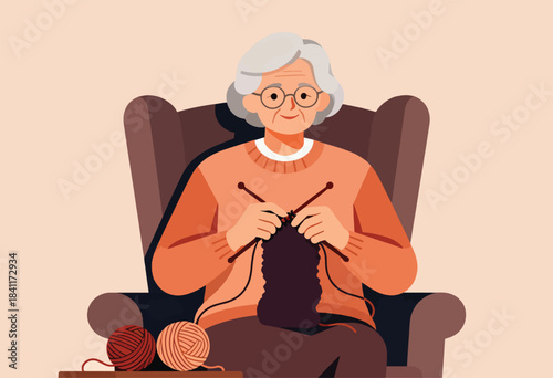 Elderly woman with gray hair sits in a chair, knitting with yarn and needles. Two balls of yarn sit near her feet