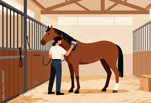 A person grooms a brown horse in a stable. The scene is inside a barn with stalls and hay on the floor