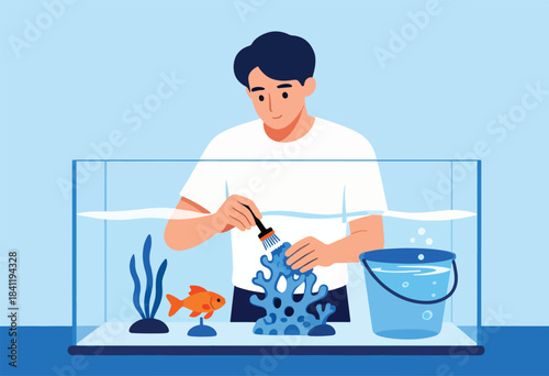 A person cleans an aquarium with a goldfish, algae, and a decorative coral structure with a bucket