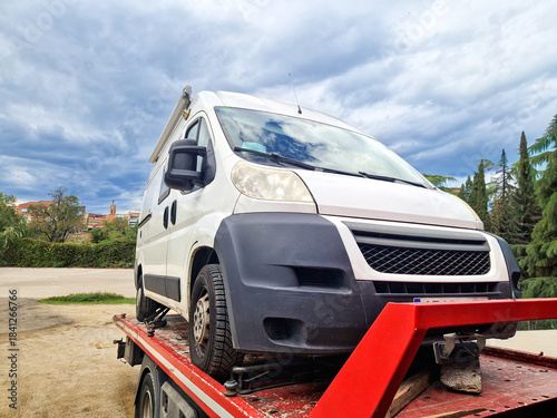 Tow truck carrying a broken down camper van