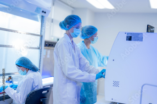 Scientists working in a modern laboratory during a research session with advanced equipment and safety measures in place