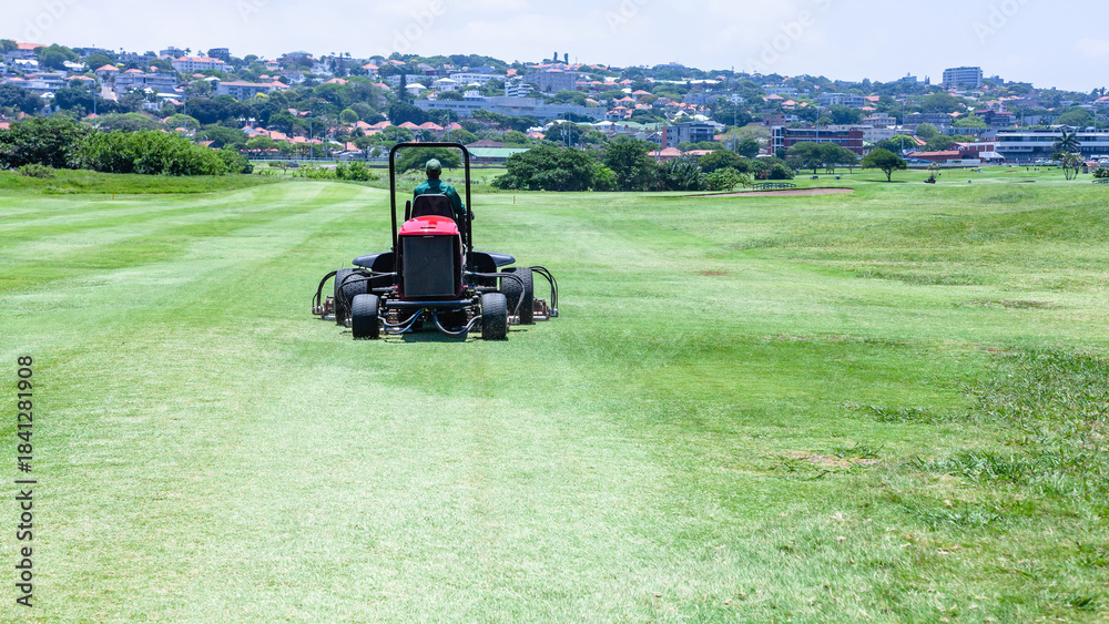 Obraz premium Golf Course Hole Maintenance Team Green Cutting Machine for Rough and Fairways