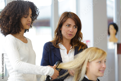 Photography hairdresser apprentice doing a hairdo to client