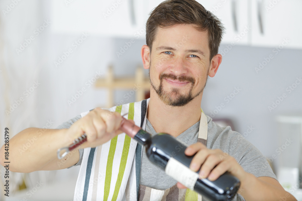 Fototapeta premium a young man opens a bottle