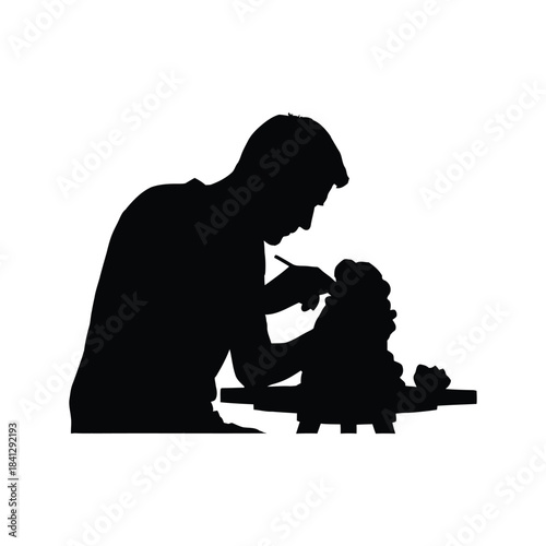 Silhouette of a father and child interacting over a tabletop activity