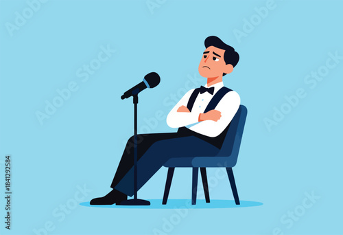 Sad man in suit sits with arms crossed facing a microphone