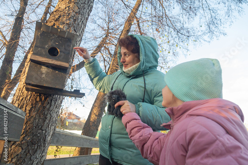 Happy moments with grandmother and little granddaughter walking in the park at autumn morning