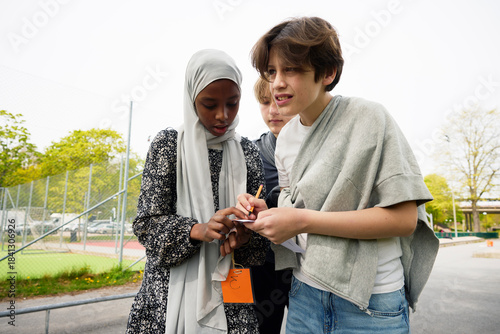 Wallpaper Mural Group of students assisting each other while playing treasure hunt in school campus Torontodigital.ca