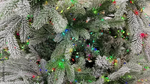 Holiday lights shine on a decorated Christmas tree in a cozy indoor space during the festive season