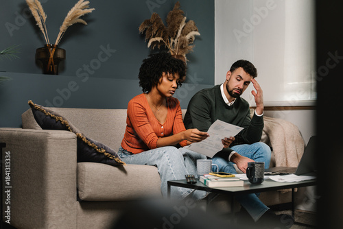 Photography Stressed couple looking worried while managing household finance bills and debts