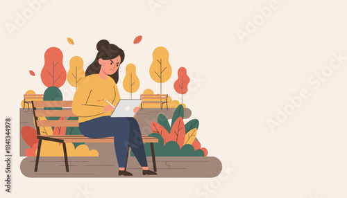 Angry young woman intensely focused on her digital tablet while sitting alone on a park bench in autumn