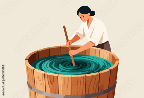 Person stirs liquid in large wooden tub