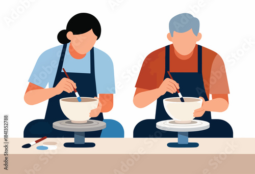 Two people in aprons are painting ceramic bowls on pottery wheels