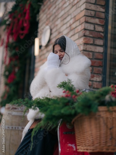 Joyful Woman Smiling Closed Eyes near scooter with Christmas decoration.