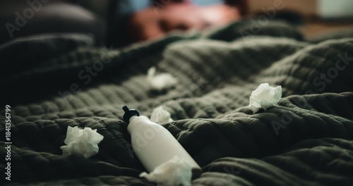 Lotion, tissues and person in bed for temptation, self pleasure and masturbation in home. Night, lubricant and man with arousal for pornography, addiction and paper towel in bedroom of apartment