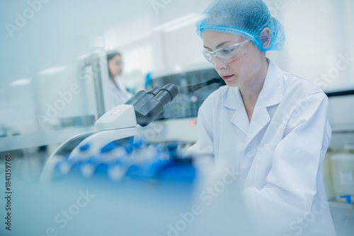 Scientist conducts research in a laboratory during daylight hours while using a microscope