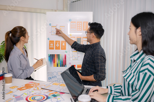 UX/UI designers collaborating during a creative workshop to test interface ideas and exchange feedback for app development, emphasizing teamwork and innovative design thinking.