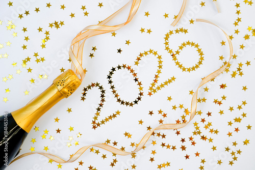 Champagne bottle stands ready to pop as golden ribbons and starry confetti spell out the year 2026 in a festive atmosphere. Perfect for welcoming the New Year with cheer