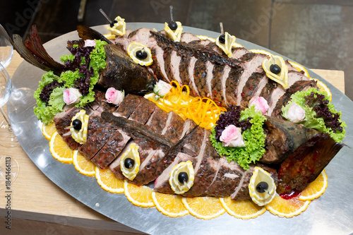 A dish of fish divided into pieces and cooked with lemon and vegetables.