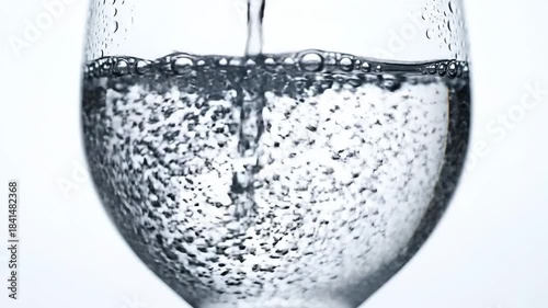 Refreshing Pour Crystal Clear Water Filling a Glass Bubbling with Freshness and Purity Ideal for Hydration and Wellness Concepts in a Clean Minimalist Setting.