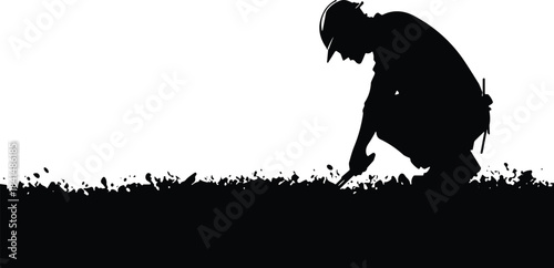 Silhouette of a construction worker or engineer in a hardhat crouching down to inspect soil or search the ground, symbolizing detailed site assessment, safety, and infrastructure development.