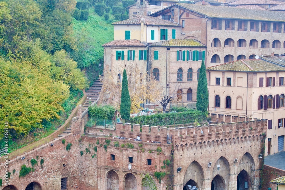 Obraz premium Siena, Italy – Historic brick architecture and hillside houses in Tuscany.