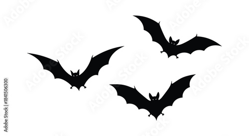 A group of three black spooky bat silhouettes flying in different directions perfect for Halloween designs and decorations.