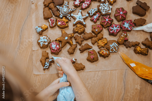 Cookies are decorated in various shapes during a baking activity on a wooden table